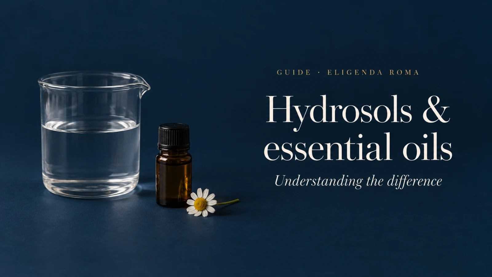 A glass vessel of water, an amber vial and a chamomile flower against navy; an illustrative still life.