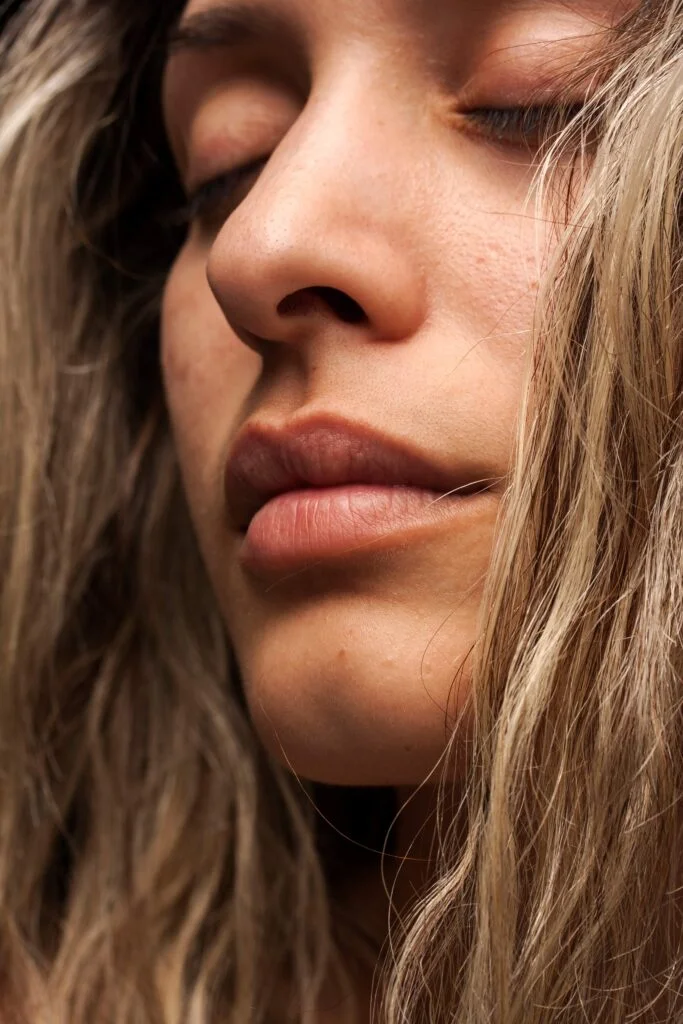 Close-up of a woman’s face with her eyes closed.
