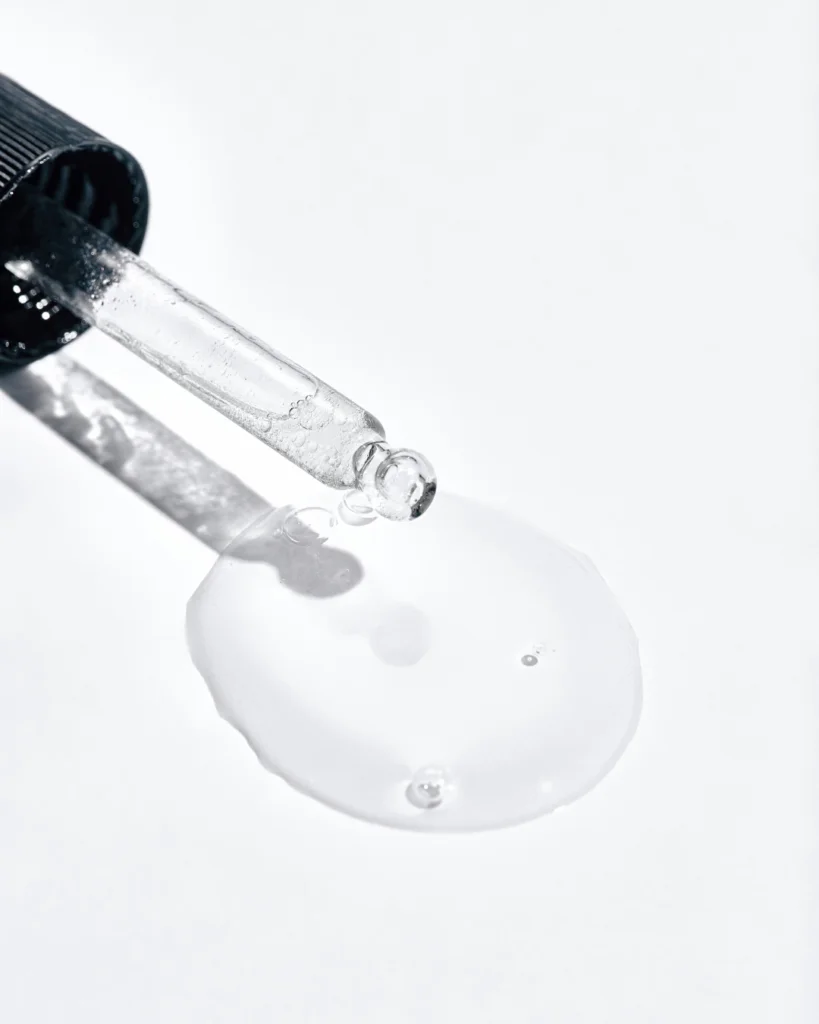 A pipette releasing a drop of clear liquid.