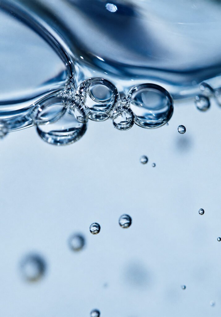Bolle d'aria in un liquido trasparente su fondo azzurro